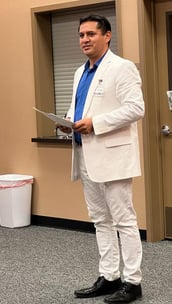 a man in a white suit and blue shirt