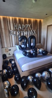 Elegant black and silver balloons decorating a room for a luxurious 30th birthday surprise.