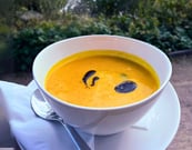 Cremige Kürbissuppe, serviert in einer Schale, dekoriert mit Kürbiskeröl aus der Seeperle in Plön