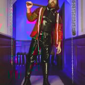 FTSH Studios model (s) Oscar Thickk UK Fetish Model wearing red vinyl jacket, latex shirt and leather riding boots