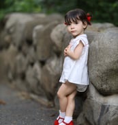 a little girl standing on a rock wall