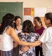 Mulheres abraçadas em roda durante encontro do projeto Maria’s