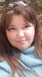 a woman with glasses and a blue sweater