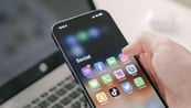 Eine Person, die ein Handy in der Hand hält, ein Symbol zur Kontaktaufnahme.