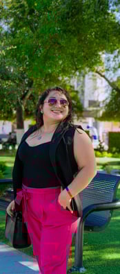 a woman in a black top and pink pants