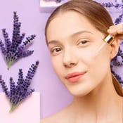 mulher passando óleo essencial no rosto e fundo de lavanda