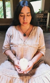 Mujer sentada sosteniendo una vela encendida