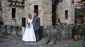 a bride and groom standing in front of a castle