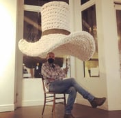 Ken Chapin sits beneath a six foot crocheted cowboy hat "Tom Mix Wept" @ BRDG Project's "True West"