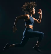 a woman in a sports bra top running in the dark
