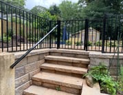 outdoor staircase with metal handrails and fence