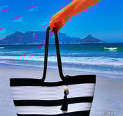 a person holding a black and white striped bag