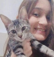a woman holding a kitten in her arms