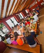 niños comiendo en el comedor del campamento