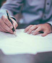 persona escribiendo con bolígrafo