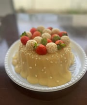 Deliciosa sobremesa com cobertura de doce de leite, decorada com morangos e bombons brancos, ideal p