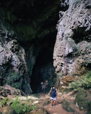 Entrance of a cave, woman standing at the entrance