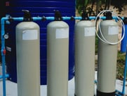 Four pressure tanks connected to water line.