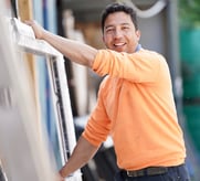 Window installer in orange shirt holding a uPVC window sill