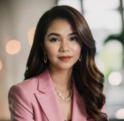 a woman in a pink suit and earrings