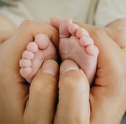 Pieds de bébé dans les mains de sa maman