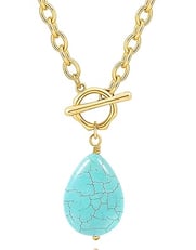 The gold pendant necklace is hanging a teardrop-shaped turquoise gemstone in the middle of the oval 