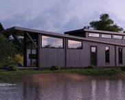 Modern prefab modular tiny home by the water at dusk