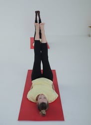 a women doing yoga with yellow tshirt and black pants