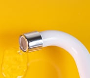 robinet blanc qui fuit sur fond jaune