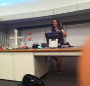 Photo of me behind a desk making my speech to the QUT students