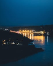 a bridge spanning a river with a bridge in the background