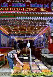 a woman is standing in front of a display of food