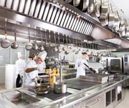 a group of chefs in a kitchen with pots and pans