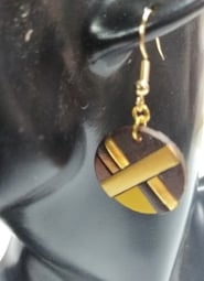 a pair of earrings with leather and gold accents