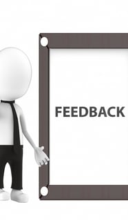 a person standing next to a sign that says feedback
