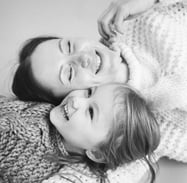 woman lying beside child and smiling