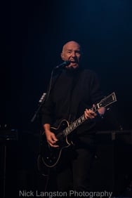 Midge Ure - singing with guitar and dark background - live at Chepstow Castle - music in Wales - Nick Langston
