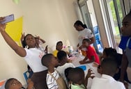 La directrice nelly prend une photo avec les enfants des l'ateliers créatifs à l'institut des frères