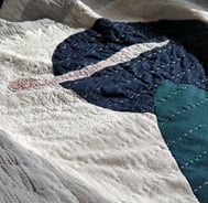 scrap fabric used to make a quilt, using applique and hand stitching.