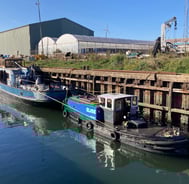 woonboot gesleept naar werf