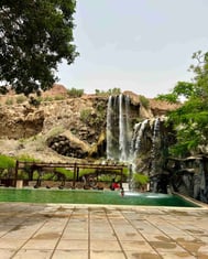 a swimming pool with a waterfall in ma'in hot springs