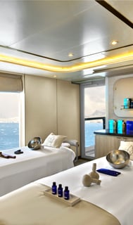 a couple of people sitting in a room with a view of the ocean