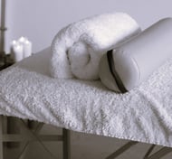 Une table de massage avec des coussins.