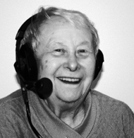 Eine lachende alte Erzählerin unter Headsets