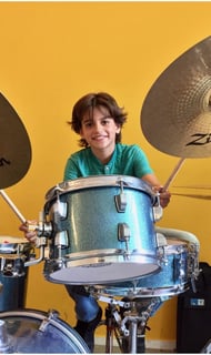a man in a green shirt playing drums