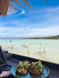 Image d'avocado on toast avec magnifique vue sur l'océan depuis un café de Nusa Ceningan.