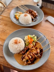 Photo d'un chicken satay avec riz et légumes servis dans un warung de Nusa Ceningan.
