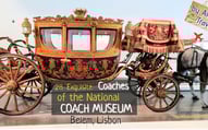 Beige & black coach decorated with royal crown & sign that says '28 coaches of National Coach Museum