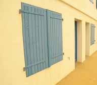 façade orange avec des volets en bois bleu 