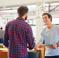 A man shaking hands with another man while smiling